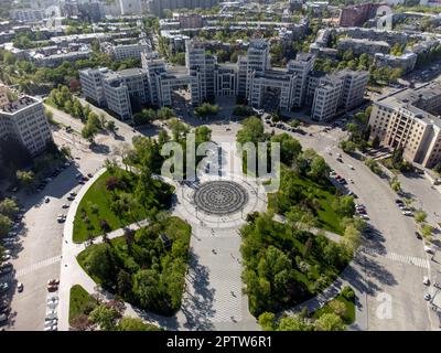 Veduta aerea verso il basso dell'edificio Derzhprom su Piazza della libertà con fontana e parco verde nella città di Kharkiv, Ucraina Foto Stock