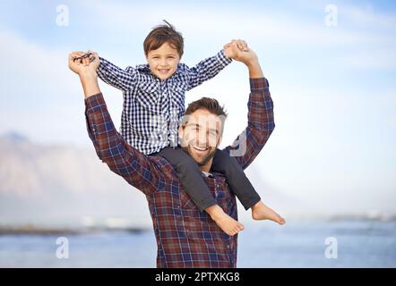 Alzando il figlio nel modo giusto. Shjot di un padre e di un figlio che si godono una giornata all'aperto Foto Stock