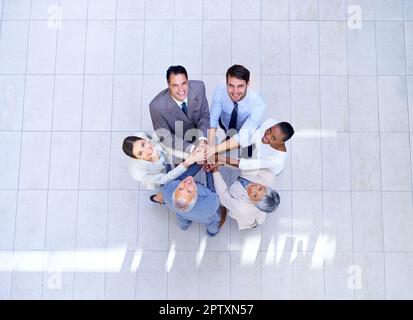 Il lavoro di squadra fa il lavoro di sogno. un gruppo di colleghi che mette le mani sopra l'altro Foto Stock