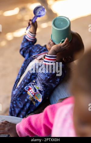 Un bambino affamato mangia un pasto di porridge di miglio da una tazza nella regione di Segou, Mali, Africa occidentale. 2022 siccità del Mali e crisi della fame. Foto Stock