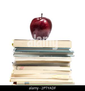 Una mela rossa sulla sommità di una pila di libri Foto Stock