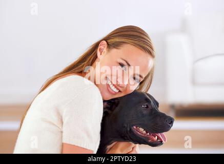 HES il mio migliore amico. Ritratto di una giovane donna attraente sorridente felicemente mentre abbraccia il suo cane Foto Stock