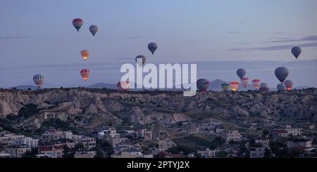 GOREME/TURCHIA - 29 giugno 2022: Paesaggio con mongolfiere nel cielo all'alba Foto Stock