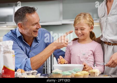 Il disordine è metà del divertimento. una famiglia che cuoce insieme e ride Foto Stock