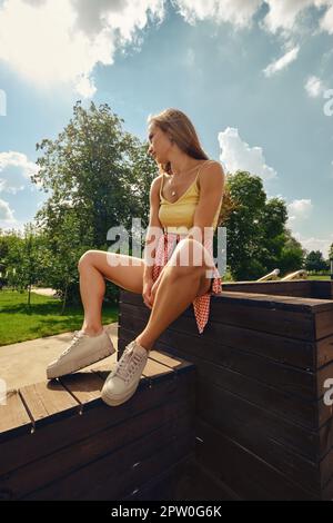 Giovane donna bella siede su pavimento di legno Foto Stock