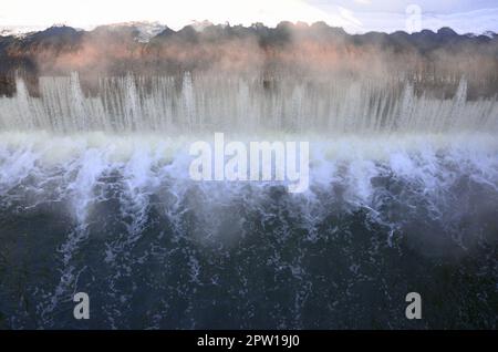 Diga per regolare il livello di acqua nel fiume. Caduta di acqua monocromatico con forti raffiche Foto Stock