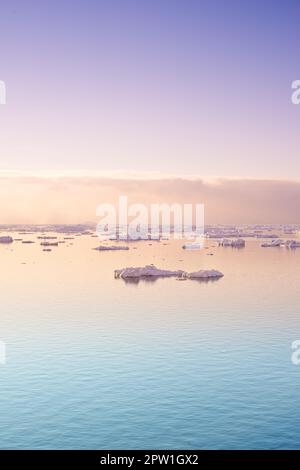 Mare con ghiacciai galleggianti all'alba. Sereno paesaggio artico invernale. Iceberg sull'orizzonte calmo del mare al tramonto in Danimarca. Scena naturale colorata di m. Foto Stock
