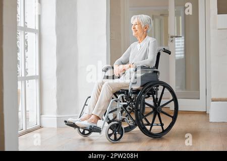 Theres ancora così tanta speranza per il mio futuro. una donna anziana seduta su una sedia a rotelle e guardando pensieroso fuori dalla finestra a casa Foto Stock