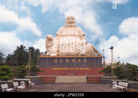 Ridendo statua del Buddha a Vinh Trang tempio, vicino a My Tho, Vietnam. Basso angolo di visione. Foto Stock