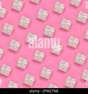 Un sacco di rosa scatole regalo giace sulla texture di sfondo fashion rosa pastello carta nel concetto di minima. Abstract disegno alla moda. Foto Stock
