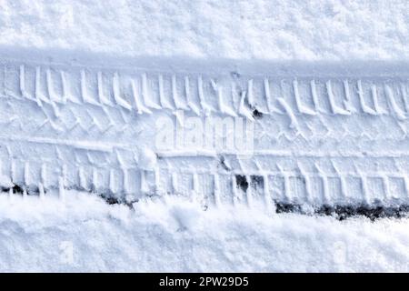 Vista ravvicinata dei cingoli degli pneumatici sulla superficie di neve fresca caduta Foto Stock