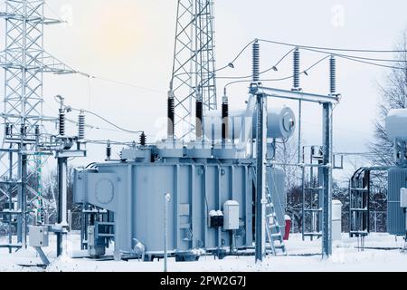 Sottostazione del trasformatore ad alta tensione in inverno. Apparecchiature ad alta tensione. Tecnologia di trasferimento di energia. Foto Stock