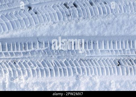 Vista ravvicinata dei cingoli degli pneumatici sulla superficie di neve fresca caduta Foto Stock