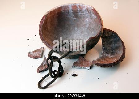 Vecchia catena rustica all'interno di vaso di argilla rotto Foto Stock