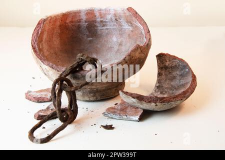 Vecchia catena rustica all'interno di vaso di argilla rotto Foto Stock