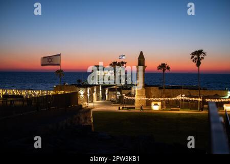 crepuscolo serale in israele a cesarea. Mare tramonto cielo e bandiere israeliane sulla riva della città vecchia. Foto di alta qualità Foto Stock