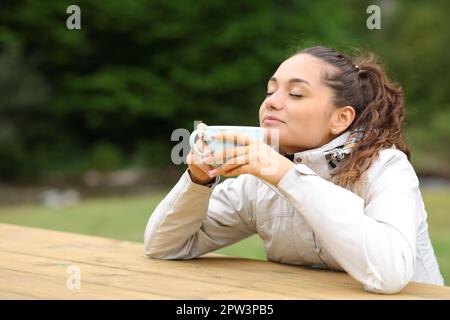 Escursionista seduto in un campeggio bere caffè e relax Foto Stock