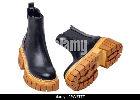 Stivali Chelsea da donna. Primo piano di un paio di stivali chelsea da donna in pelle nera con tacco alto isolato su sfondo bianco. Macro. Pubblicità di moda Foto Stock