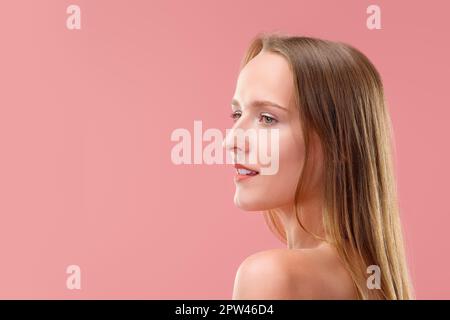 Bella donna senza trucco e con pelle sana e denti bianchi che si posano nel profilo. Foto Stock