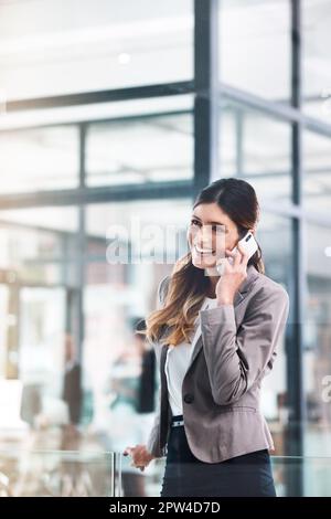 Grazie per avermi chiamato. una giovane donna d'affari che utilizza un telefono cellulare in un ufficio moderno. Foto Stock