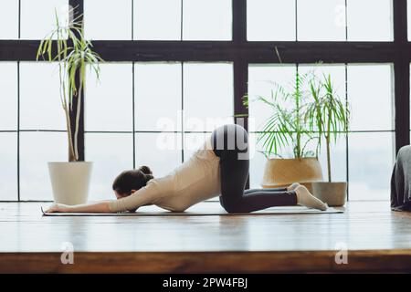 Meditazione durante la gravidanza. Giovane calma tranquilla donna incinta che fa yoga a casa, meditando e praticando la consapevolezza, donna in attesa seduta Foto Stock