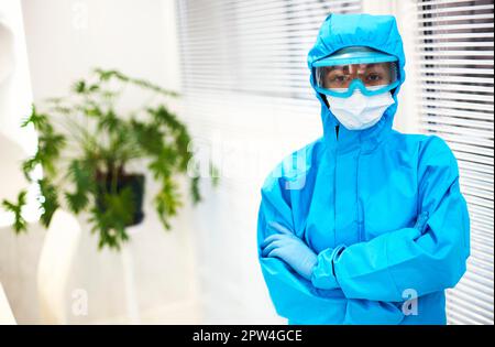 Ritratto di giovane operatore sanitario o infermiera afro-americana stanco in abbigliamento protettivo e maschera facciale e guardando la macchina fotografica con espressione frustrata. Foto Stock