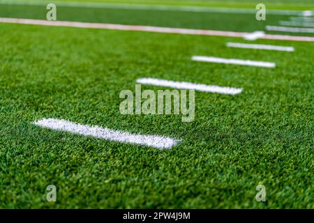 Primo piano nel tardo pomeriggio con una foto di simboli hash su un campo da calcio sintetico in erba sintetica. Foto Stock