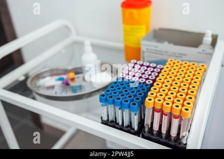 Provette per analisi del sangue sul tavolo di vetro in clinica. Primo piano Foto Stock