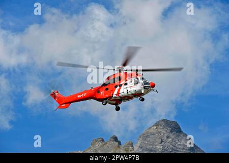 Elicottero da trasporto multiuso AS 332 Super Cougar C1 HB-XVY di Heliswiss International AG si aggira su una vetta di montagna, Vallese, Svizzera Foto Stock