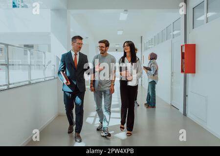 Un team aziendale che discute di idee aziendali mentre cammina attraverso una società moderna Foto Stock