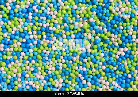 Immagine di sfondo di una varietà di vetri colorati in polvere in forma di piccole sfere. Un numero enorme di dolce, perline colorate di dimensione molto piccola per dec Foto Stock