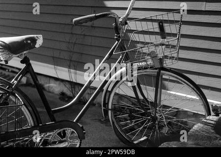 Una donna d'epoca Schwinn bicicletta con cesto sul manubrio parcheggiato di fronte a una casa a North Hampton, New Hampshire. L'immagine è stata acquisita su Foto Stock