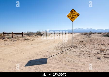 Un cartello recita la END COUNTY SERVICED ROAD nel deserto del Mojave vicino a Palmdale, California Foto Stock