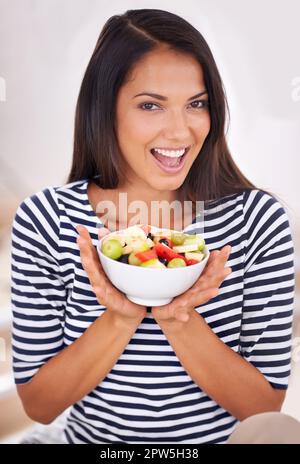 Indovinate cosa serve per dessert. Ritratto di una bella giovane donna che tiene la sua insalata di frutta Foto Stock