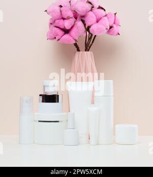 Vasetti e tubi in plastica bianca per cosmetici liquidi su fondo bianco. Branding, pubblicità Foto Stock