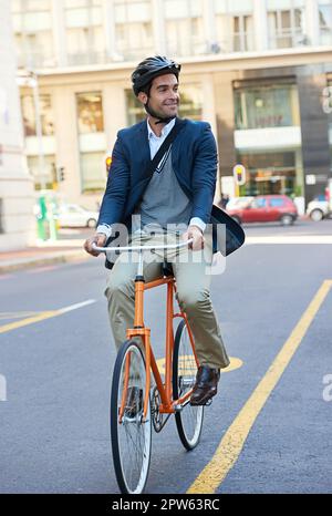 Pendolarismo senza carbonio. un bel uomo d'affari che viaggia per lavoro in bicicletta in città Foto Stock