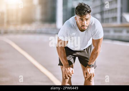 Uomo riposante, dopo jogging e corsa in città per il fitness. Runner sano, in forma e da solo che cattura il respiro dopo una corsa al mattino. Formazione Foto Stock