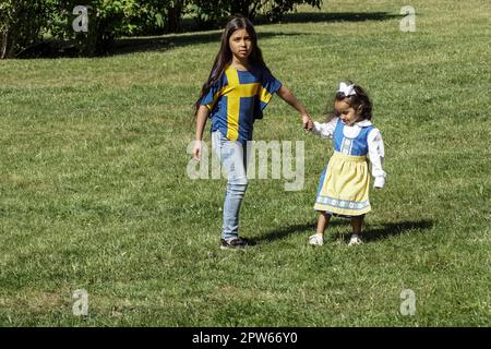 Due sorelle si trovano sul prato durante la Giornata Nazionale Svedese Foto Stock