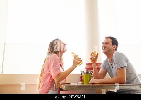 Condividere un sundowner. Una giovane coppia felice che si gode una bevanda alcolica in un ristorante Foto Stock