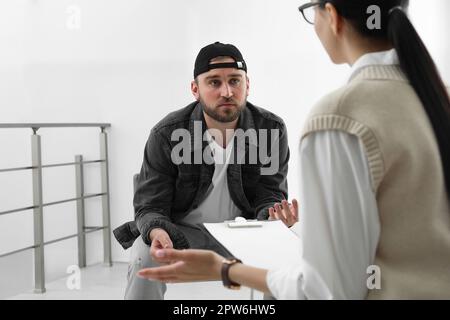 Psicoterapeuta che lavora con un giovane tossicodipendente al chiuso Foto Stock