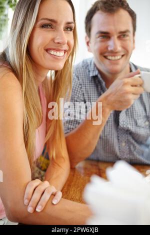 Inizia la giornata con una birra forte. Una giovane coppia attraente che si gode una tazza di caffè nel ristorante Foto Stock