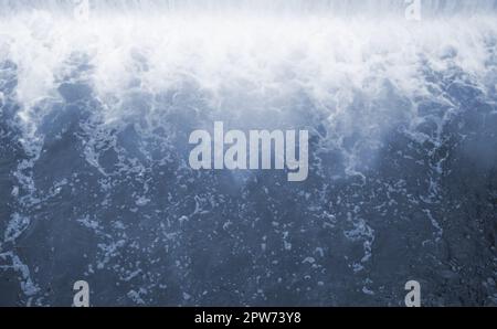 Diga per regolare il livello di acqua nel fiume. Caduta di acqua monocromatico con forti raffiche Foto Stock