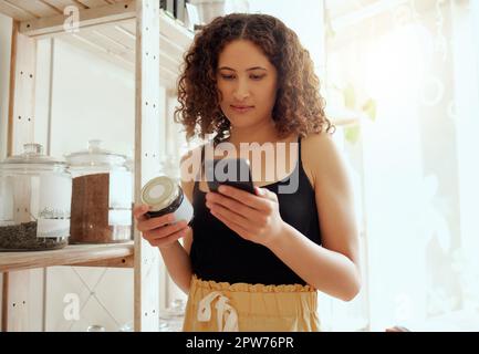 Consumatore o cliente con telefono cellulare che cerca informazioni sui prodotti biologici online per ingredienti etici, vegani o sani. Acquirente eco consapevole rea Foto Stock