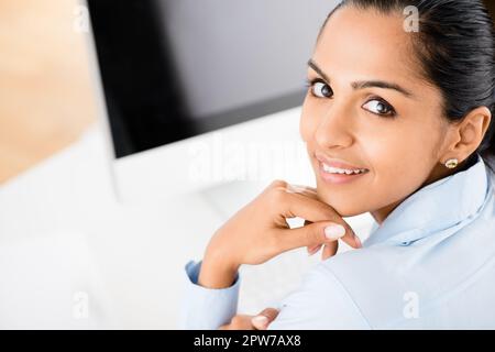 Il lavoro non si ferma mai. una giovane donna indiana che lavora alla sua scrivania Foto Stock