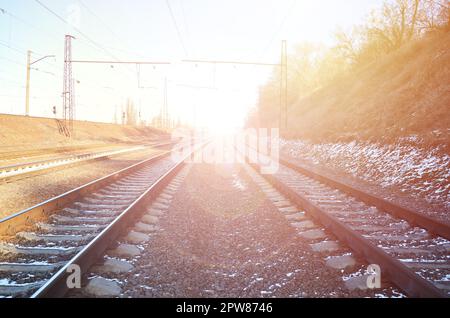 Paesaggio di un nevoso inverno russo railway sotto la luce diretta del sole le rotaie e le traversine al di sotto del dicembre neve. Le Ferrovie russe in dettaglio Foto Stock