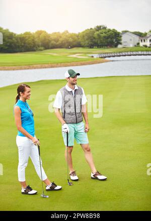 Il golf vi permette di trascorrere del tempo di qualità con i vostri cari. Scatto completo di una giovane coppia fuori sul campo da golf. Foto Stock