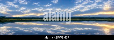 Sera cielo nuvoloso riflesso nel lago. paesaggio nuvolato. nuvole nel cielo blu e riflesso nel grande lago. Nuvole bianche di cumuli nel cielo sopra l'acqua blu del mare. , Foto Stock