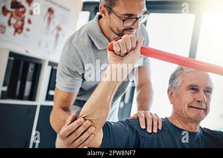 HES continua a essere forte. un fisioterapista amichevole che aiuta il paziente maturo ad allungarsi in un centro di riabilitazione. Foto Stock