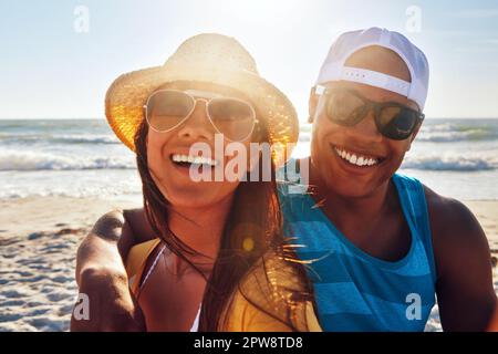 Im fortunato ad essere innamorato del mio migliore amico. Ritratto di una giovane coppia seduta sulla spiaggia in una giornata di sole. Foto Stock