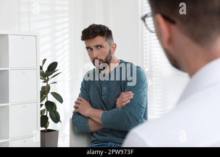 Psicoterapeuta che lavora con l'uomo tossicodipendente al chiuso Foto Stock